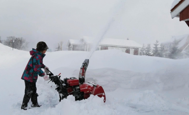 女性が除雪機を使っている